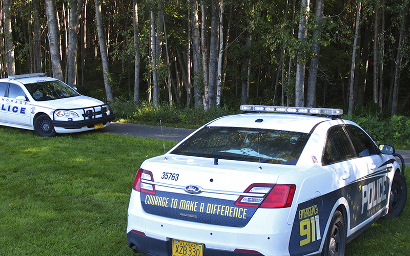 Police cars are stopped at Valley of the Moon Park where two people were found dead last weekend in Anchorage, Alaska. The double homicide is among nine unsolved cases this year in which people have been found dead in Anchorage parks, trails and on isolated streets. 