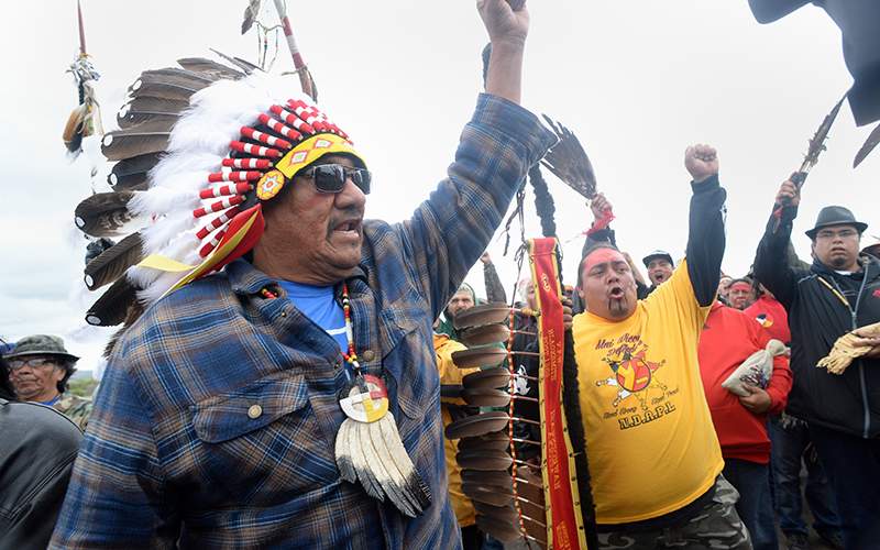 JR American Horse, left, raises his fist with others while leading a march to the Dakota Access Pipeline site in southern Morton County North Dakota. Several hundred protesters marched about a mile up Hwy 1806, Friday Sept. 9, 2016, from the protest camp to the area of the pipeline site where some archeological artifacts have been discovered. 