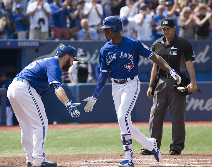 Toronto Blue Jays center fielder Melvin Upton Jr. (7) is greeted at home plate by teammate Toronto Blue Jays catcher Russell Martin (55) after Upton Jr's homer during second inning American League MLB baseball action in Toronto on Saturday.