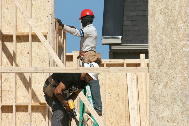 Construction workers work on a new home at a job site in Oakville, Ont.