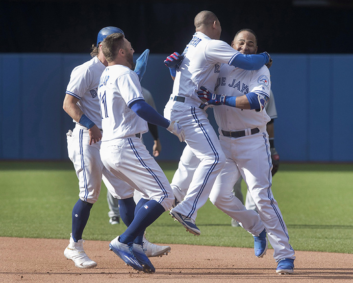 Toronto Blue Jays Edwin Encarnacion (right) is mobbed by teammates (left to right) Josh Donaldson, Kevin Pillar and Ezequiel Carrera after he drove in the winning run in the ninth inning of their American League MLB baseball game against the New York Yankees in Toronto Sunday.