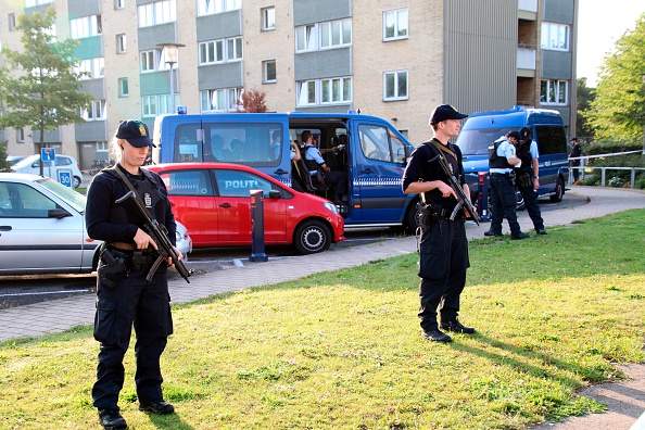 Policemen guard the area where a shooting took place in at Copenhagen's Christiania district, on September 1, 2016. 
Two police officers were wounded in a shootout during an arrest of a suspected person.