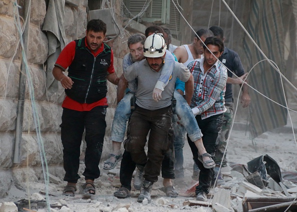 Search and rescue team members carry a wounded man after warcrafts belonging to Syrian army carried out airstrikes over Aleppo's Sukkeri region, Syria on September 20, 2016.