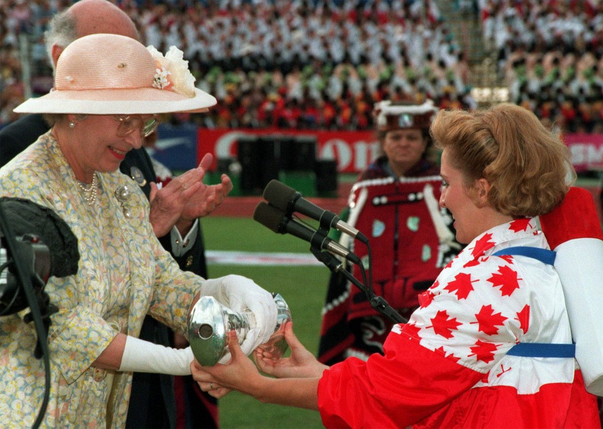 Canadian Olympic Gold medallist Myriam Bedard hands the Queens Baton over to Queen Elizabeth II during Commonwealth Games opening ceremonies in Victoria, B.C., Aug. 18, 1994. 