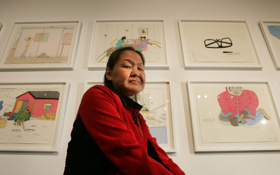 Annie Pootoogook is framed by her artwork on display at The Power Plant in Toronto on June 22, 2006.