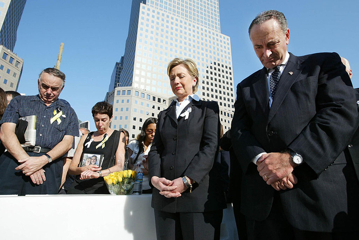 U.S. Senators Hillary Rodham Clinton (C) and Charles Schumer (R) bow their heads during a moment of silence at the ceremony to mark the two-year anniversary of the attacks on the World Trade Center September 11, 2003 in New York City.