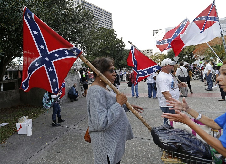 Arlene Barnum, of Oklahoma, with a group calling themselves Confederate Veterans Lives Matter, holds a Confederate flag in front of City Hall in New Orleans, Thursday, Dec. 10, 2015. City Hall became the scene of competing opinions over the removal of prominent Confederate monuments along some of New Orleans' busiest thoroughfares. The City Council set aside time to let the public voice feelings over a proposal to remove four monuments linked to Confederate history.