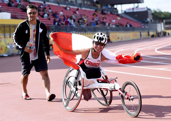 Michelle Stilwell shows off the Canadian flag after winning gold in the women's 100m T52 final during the Para Pan American Games in Toronto in August 2015.