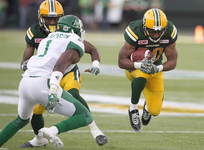 Edmonton Eskimos' John White (30) runs against the Saskatchewan Roughriders' Buddy Jackson (1) defends during first half action in Edmonton, Alta., on Friday July 8, 2016. The Saskatchewan Roughriders' defence will try to slow down Edmonton's running game on Sunday when the Eskimos visit for the final regular season game between the two West Division teams.