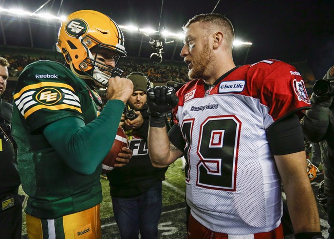 Calgary Stampeders quarterback Bo Levi Mitchell, right, and Edmonton Eskimos quarterback Mike Reilly embrace following the CFL West Division final in Edmonton, Sunday, Nov. 22, 2015. Labour Day's Battle of Alberta in the CFL will showcase of the top two quarterbacks in the league. Edmonton's Reilly and Calgary's Mitchell rank first and second respectively in passing yards and touchdown throws at the halfway mark of the season.