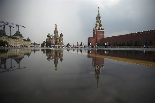 St. Bazil's Cathedral, center, and the Kremlin's Spasskaya Tower, right, are reflected in a puddle at the Red Square after a heavy rain in Moscow, Russia, Wednesday, July 27, 2016.