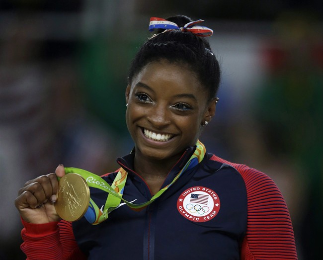 United States' Simone Biles displays her gold medal for floor during the artistic gymnastics women's apparatus final at the 2016 Summer Olympics in Rio de Janeiro, Brazil, Tuesday, Aug. 16, 2016. Biles is ready to tell the full story behind her rise from prodigy to champion.