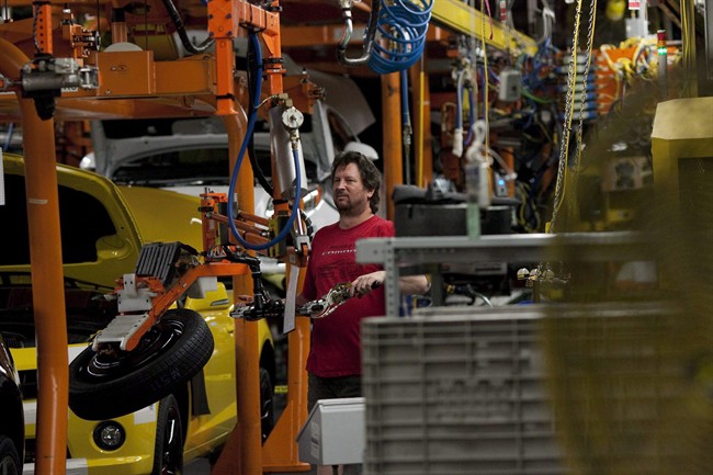 An assembly line worker at the General Motors Assembly plant in Oshawa works on a car on Friday, December 16, 2011. 