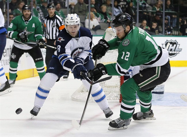 Winnipeg Jets' Jacob Trouba and Dallas Stars' Radek Faksa compete for control of the puck in the first period of an NHL hockey game on Feb. 25, 2016.