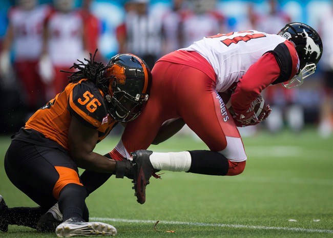 B.C. Lions' Solomon Elimimian, left, tackles Calgary Stampeders' Bakari Grant during the first half of a CFL football game in Vancouver, B.C., on Friday, August 19, 2016.