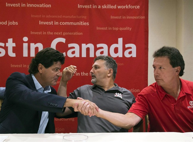 Unifor national president Jerry Dias, left, shakes hands with bargaining committee member Chris Taylor, right, of Ford Motor Company, as bargaining committee member Dino Chiodo, of Fiat Chrysler, sits between them, after the conclusion of a news conference regarding the ongoing Canadian Auto Workers union talks, Thursday, Aug. 11, 2016, in Toronto. 
