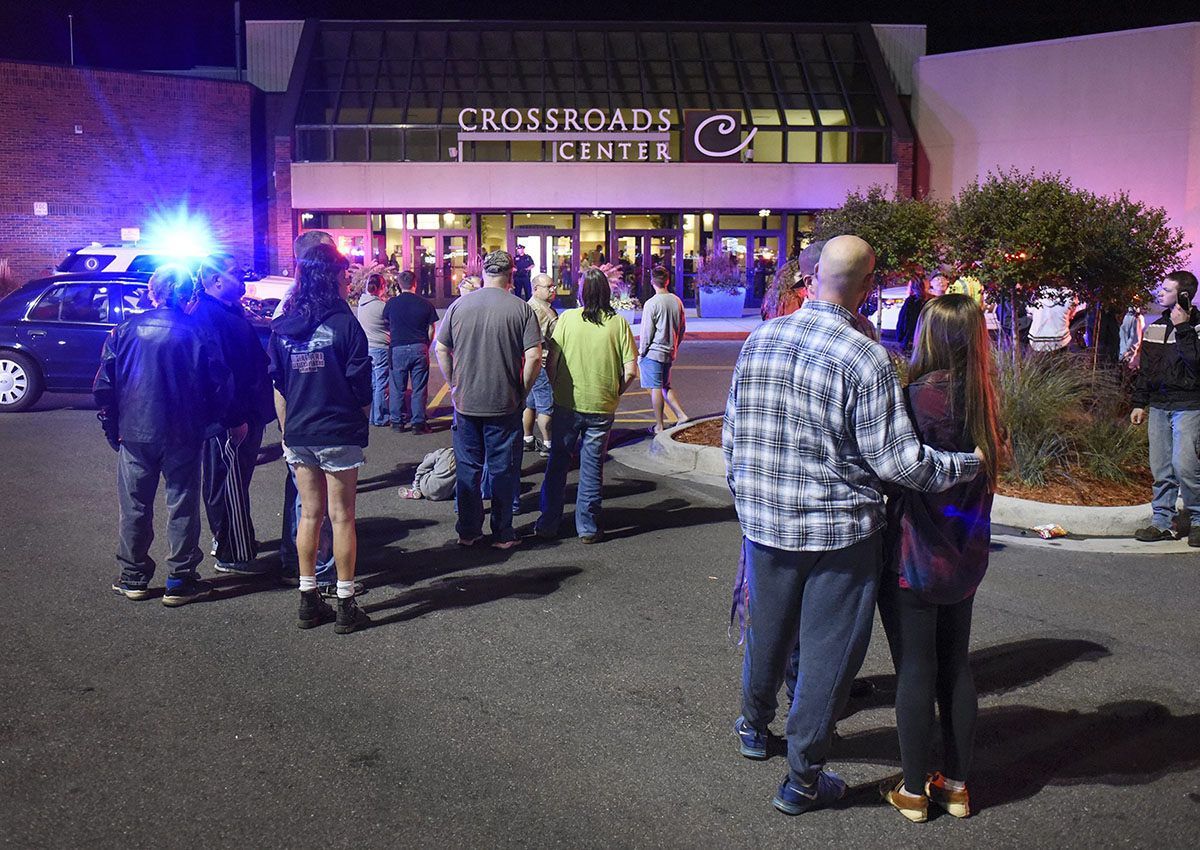 People stand near the entrance on the north side of Crossroads Center shopping mall in St. Cloud, Minn., Saturday, Sept. 17, 2016. Transcripts of 911 calls from the time of the attack have been released.