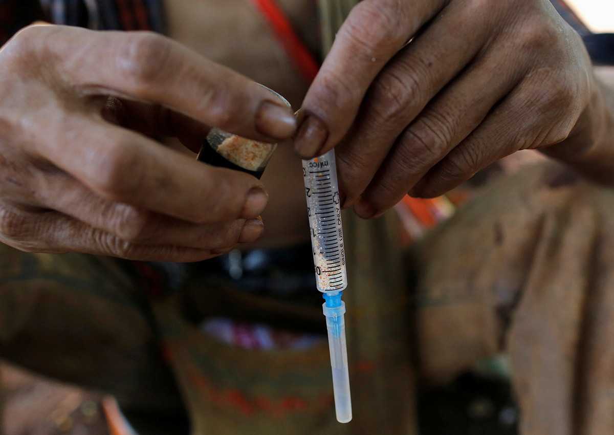 A man prepares to inject heroin along a street in Man Sam, northern Shan state Myanmar July 11, 2016.  Picture taken July 11, 2016. 