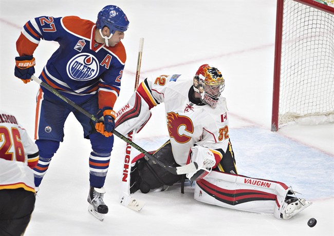Calgary Flames' goalie Jon Gillies (32) makes the save on Edmonton Oilers' Milan Lucic (27) during third period NHL pre-season action, in Edmonton on Monday, September 26, 2016. 