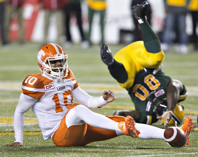 B.C. Lions quarterback Jonathon Jennings (10) is sacked by Edmonton Eskimos Almondo Sewell (90) during second half CFL action in Edmonton, Alta., on Friday September 23, 2016. 