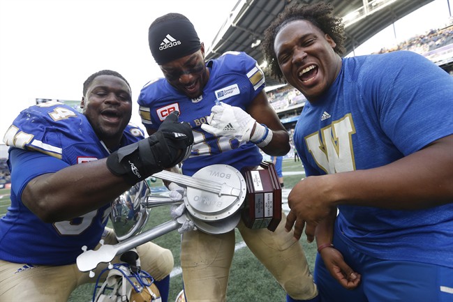 Winnipeg Blue Bombers' Euclid Cummings, Gerrard Sheppard and Padric Scott strum the Banjo Bowl after defeating the Saskatchewan Roughriders in CFL action in Winnipeg Saturday, September 10, 2016.