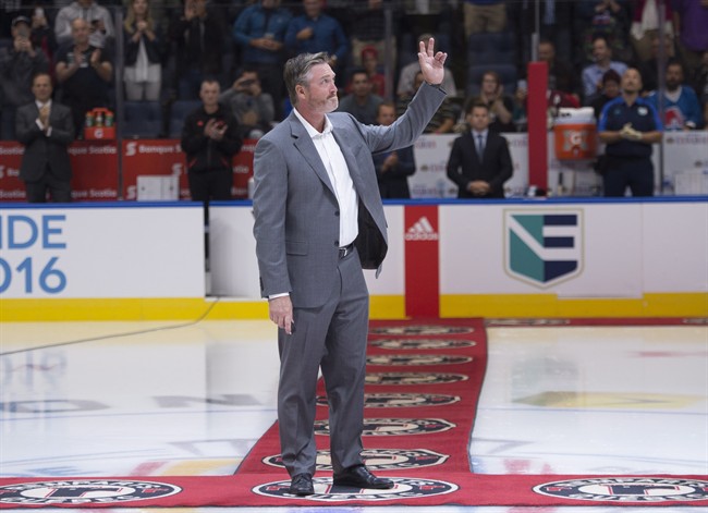 NHL hockey legend Patrick Roy waves to the applauding crowd before dropping the puck for a ceremonial face-off as Team Europe and Team North America play a pre-tournament game at the World Cup of Hockey, Thursday, September 8, 2016 in Quebec City. 