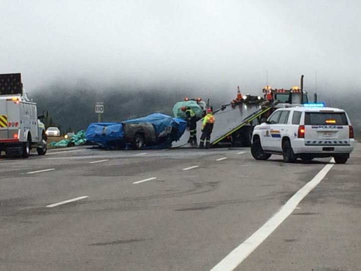 Crews remove the burned remains of a pickup truck involved in a double-fatal collision near Lac des Arcs on Sept. 4, 2016.