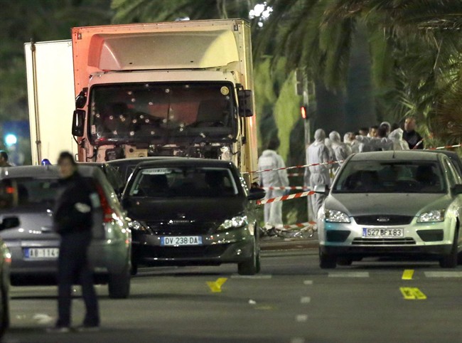 FILE - In this July 15, 2016 file photo, forensic officers stand near a truck with its windscreen riddled with bullets that plowed through a crowd of revelers who'd gathered to watch the fireworks in the French resort city of Nice, southern France. French authorities have made eight new arrests in connection with the Bastille Day truck attack in Nice that left 86 people dead, the Paris prosecutor's office said on Tuesday, Sept. 20, 2016. (AP Photo/Claude Paris, File).