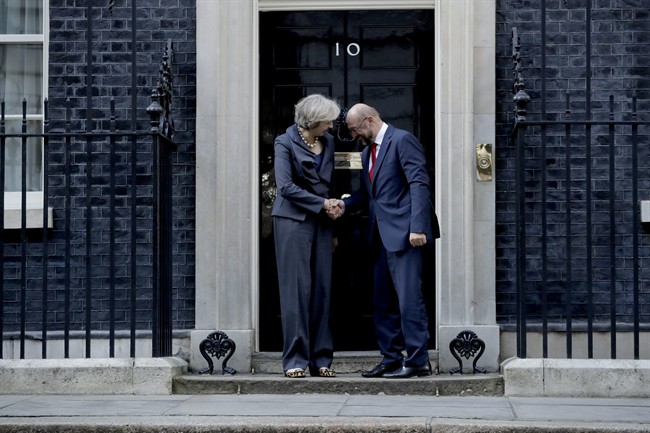British Prime Minister Theresa May and the President of the European Parliament Martin Schulz perform a posed handshake for the media before their talks at 10 Downing Street in London, Thursday, Sept. 22, 2016.