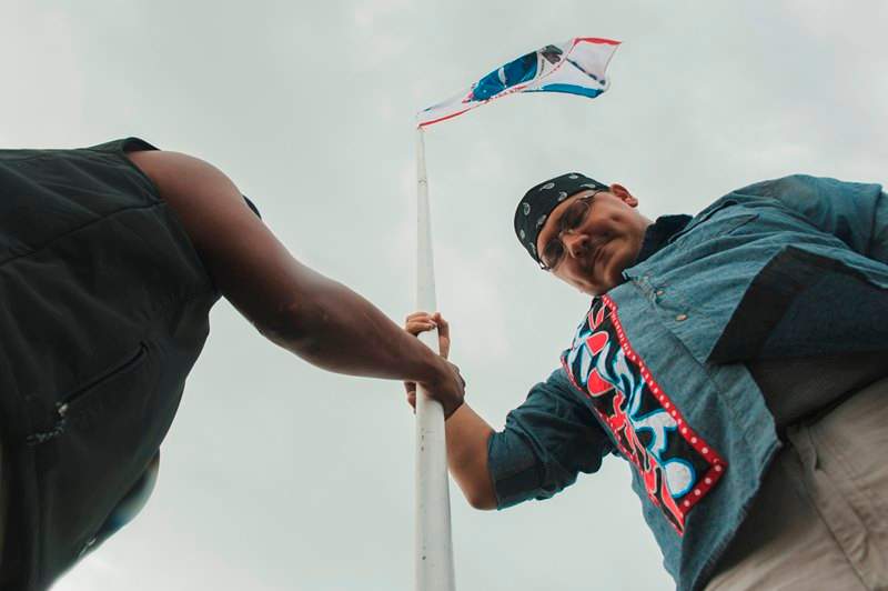 James Day (R), raises a flag with a group from the Saginaw Chippewa Reservation in Mount Pleasant, Michigan.