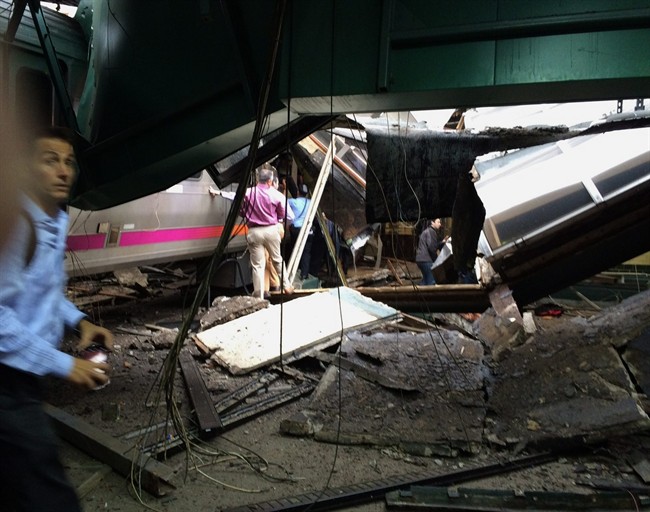In a photo provided by William Sun, people examine the wreckage of a New Jersey Transit commuter train that crashed into the train station during the morning rush hour in Hoboken,, N.J., Thursday, Sept. 29, 2016. The crash caused an unknown number of injuries and witnesses reported seeing one woman trapped under concrete and many people bleeding. (William Sun via AP).