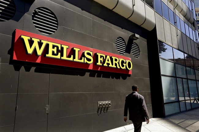  In this July 14, 2014, file photo, a man passes by a Wells Fargo bank office in Oakland, Calif. Regulators announced Thursday, Sept. 8, 2016, that Wells Fargo is being fined $185 million for illegally opening millions of unauthorized accounts for their customers in order to meet aggressive sales goals. 
