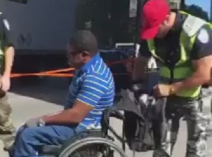 A Montreal police officer searches inside the bag of a wheelchair-bound man, Wednesday, September 21, 2016.