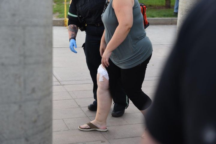 A paramedic escorts a woman away from the Prairie Mall in Grande Prairie, Alta. on Sept. 15, 2016.