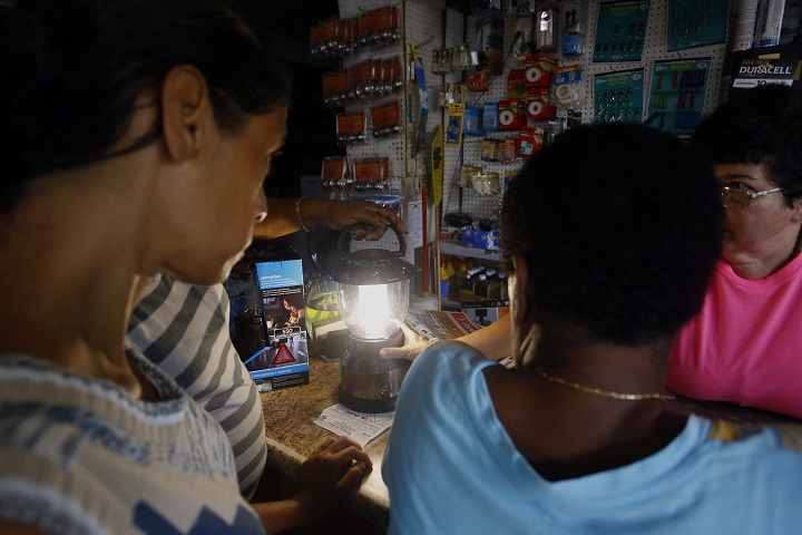 A group of people share a flashlight in San Juan, Puerto Rico, on Sept. 22, 2016. The country is mired in the worst blackout in the last 36 years, due to a fire in an thermoelectric station in Aguirre.