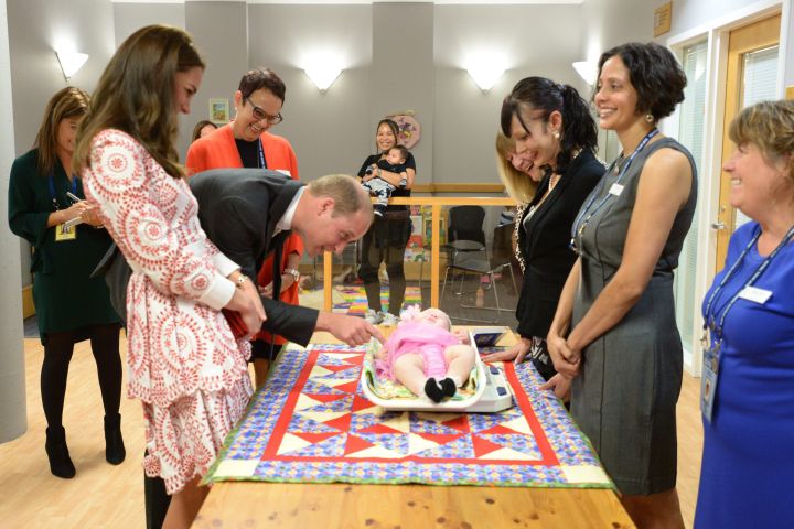 Britain’s Prince William tickles a baby as his wife Kate, Duchess of Cambridge, looks on during a tour of Sheway, a centre that provides support for native women, in Vancouver, B.C., Sunday, Sept. 25, 2016.