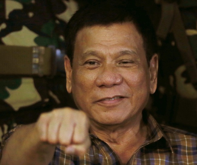 In this Aug. 25, 2016, file photo, Philippine President Rodrigo Duterte gestures with a fist bump during his visit to the Philippine Army's Camp Mateo Capinpin at Tanay township, Rizal province east of Manila, Philippines.