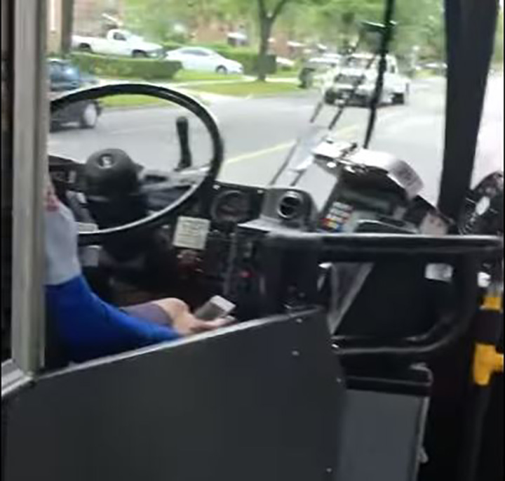 A screenshot from a video on YouTube shows a TTC driver holding a cellphone.
