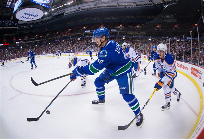 Vancouver Canucks' Mike Zalewski, centre, has his clearing pass stopped by Edmonton Oilers' Kris Versteeg, back left, as Drake Caggiula, right, watches during the first period of a pre-season NHL hockey game in Vancouver, B.C., on Wednesday September 28, 2016.