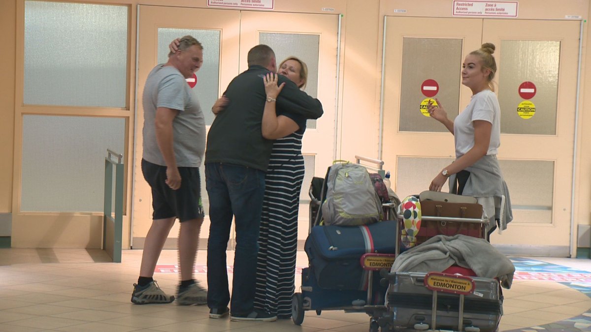 A family greets a passenger arriving in Edmonton on a WestJet flight after a harrowing ordeal.