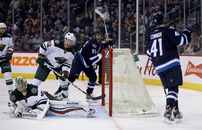 Winnipeg Jets Mathieu Perreault and Kyle Connor celebrate after Connor scored on Minnesota Wild's goaltender Darcy Kuemper in the second period of Thursday's pre-season game.