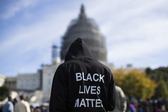 In this file photo, a man wears a hoodie that reads, 'Black Lives Matter', as stands on the lawn of the Capitol building on Capitol Hill in Washington during a rally to mark the 20th anniversary of the Million Man March.