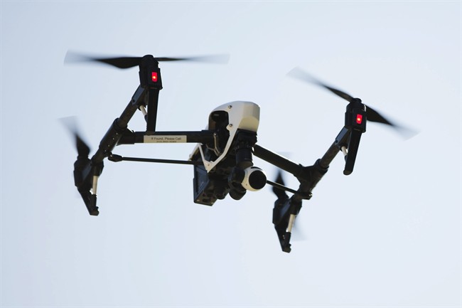 An unmanned aerial device, or drone, is pictured flying in the air.