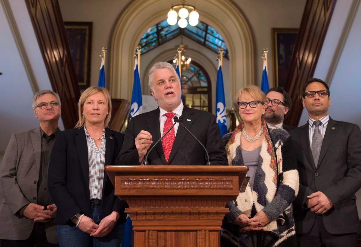 Gerry Sklavounos (far right) stands with Quebec Premier Philippe Couillard and fellow party members at a news conference at the end of a pre-session caucus, Friday, February 5, 2016 at the legislature in Quebec City.