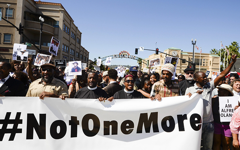 Protesters march through downtown El Cajon, Calif.,  Saturday Oct. 1, 2016, in reaction to the fatal police shooting of Alfred Olango, an unarmed black man. Olango, a Ugandan refugee, was shot by an El Cajon police officer on Tuesday.  