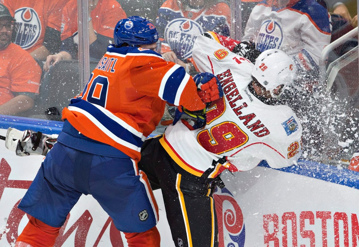 Calgary Flames' Deryk Engelland (29) is checked by Edmonton Oilers' Leon Draisaitl (29) during third period NHL action in Edmonton, Alta., on Wednesday October 12, 2016. 