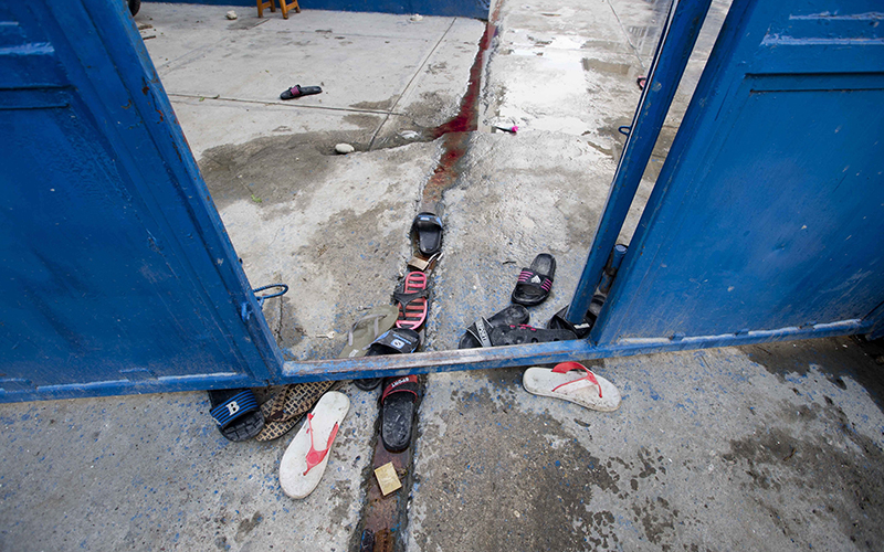 Inmates' sandals lay at the main gate of the Civil Prison in the coastal town of Arcahaiea, Haiti, Saturday, Oct. 22, 2016. 
