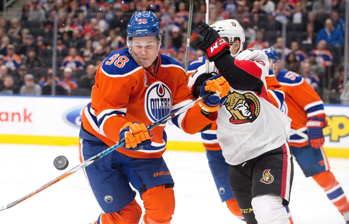 Ottawa Senators' Ryan Dzingel (18) and Edmonton Oilers' Jesse Puljujarvi (98) battle for the loose puck during third period NHL action in Edmonton, Alta., on Sunday October 30, 2016. 