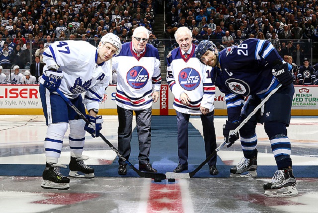 Winnipeg Jets captain Blake Wheeler and Leo Komarov of the Toronto Maple Leafs pose with former Jets Ulf Nilsson and Anders Hedberg for the ceremonial puck drop prior to Wednesday's game.