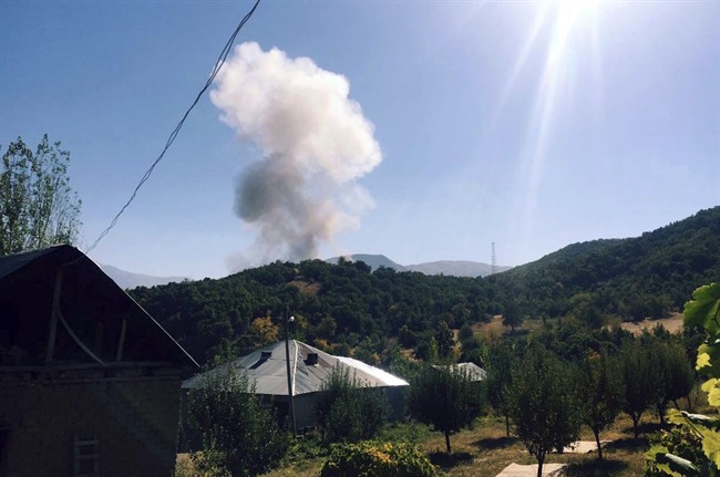 Smoke rise after Kurdish militants detonated a car bomb outside a military station in Semdinli near the border with Iraq, Turkey, Sunday, Oct. 9, 2016. 